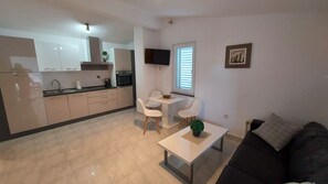 Una cocina moderna con armarios blancos y un comedor con mesa y sillas.