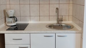 A kitchen with white cabinets, a coffee maker, and a sink. - Marvelous 5-bedroom house with great terrace in Pješčana Uvala (Pješčana Uvala)