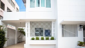 Ein modernes Gebäude mit weißer Fassade, einem geometrischen Fensterdesign und der sichtbaren Nummer 103.