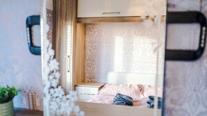 A compact bedroom with a bed, bedside table, and a window with curtains. - Modern 3-Bed - Near Etihad & City Centre (Manchester)