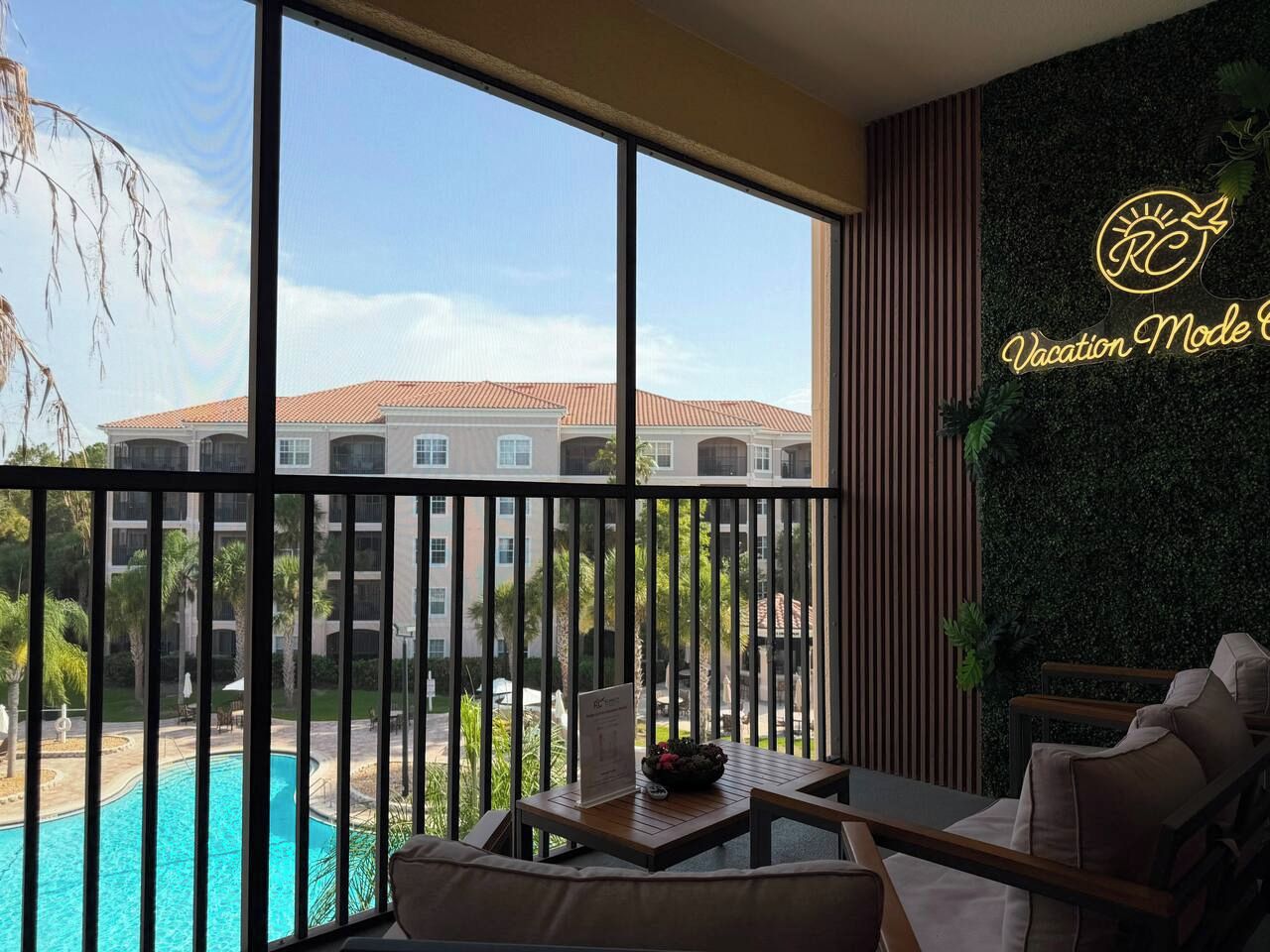 Un balcón con vistas a una piscina y un edificio al fondo.