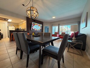 A modern living space with a dining area, kitchen, and seating area. - Luxury Disney Escape • Private Balcony • Lake & Pool Views (Orlando)