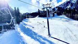 En skilift med stole, der bevæger sig op og ned ad en sneklædt skråning.