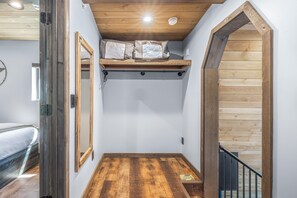 A narrow hallway with a wooden ceiling, a loft bed with a mattress and pillows, and a wooden door. - Newly Remodeled A-Frame 5 min drive to Sundance (Sundance)