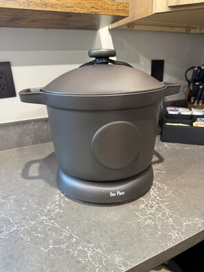 A modern kitchen with a grey electric stove, a pot on top, and a countertop with a knife block and other kitchen items. - Newly Remodeled A-Frame 5 min drive to Sundance (Sundance)