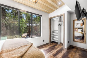 A bedroom with a large window, a bed, a wardrobe, and a TV mounted on the wall. - Newly Remodeled A-Frame 5 min drive to Sundance (Sundance)