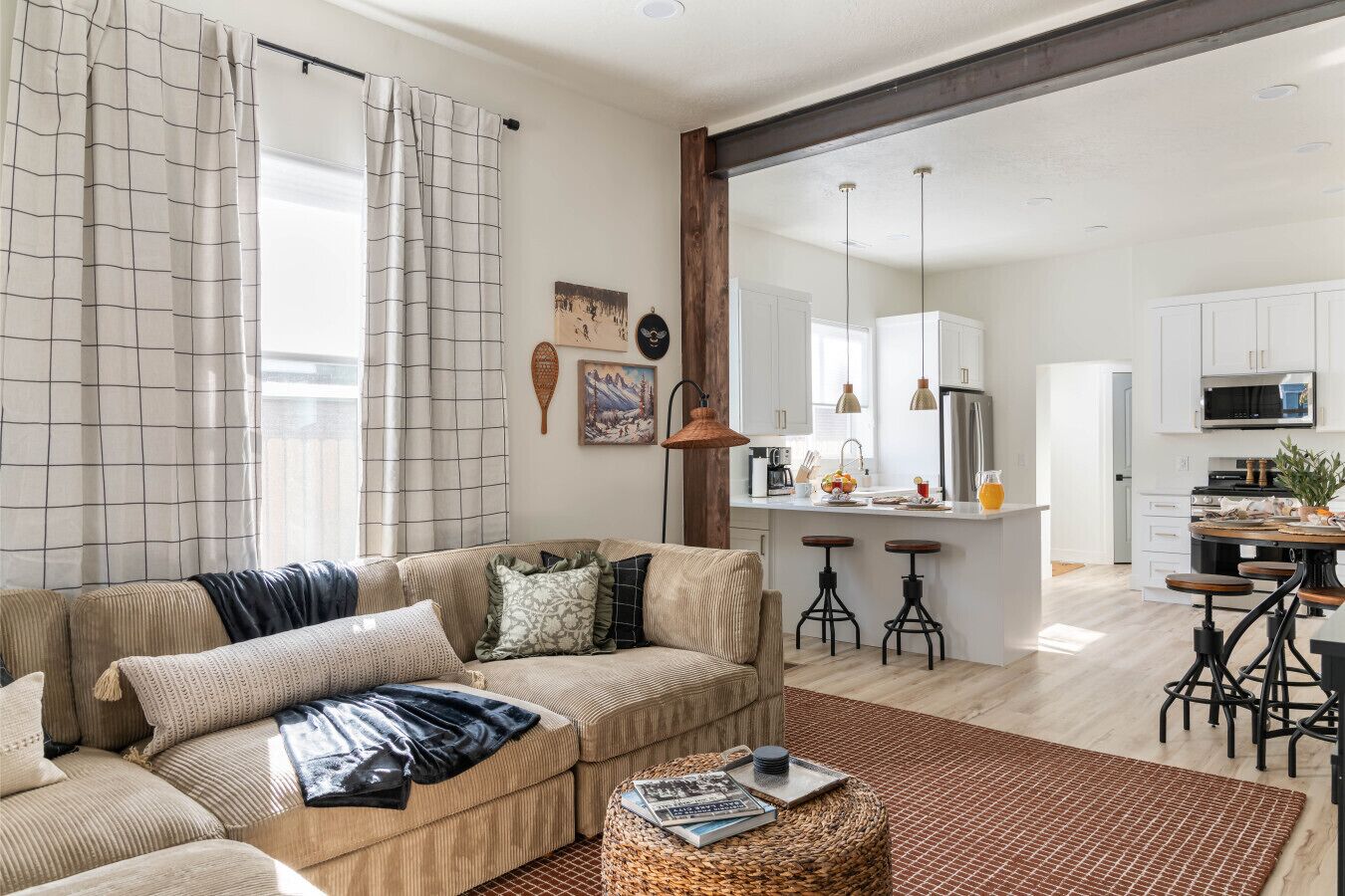 A modern living room with a sofa, coffee table, and a kitchen area with bar stools.