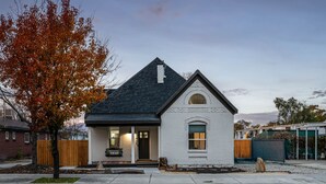 A single-story house with a dark roof, a front porch, and a small attached garage. - Ski Lodge, Ski Drop, Pickleball, HotTub, Sleeps 12 (South Salt Lake)