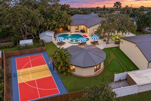 A residential property with a basketball court, swimming pool, and a covered patio area. - Private Pickleball, Heated Pool & Spa, Theater (Largo)