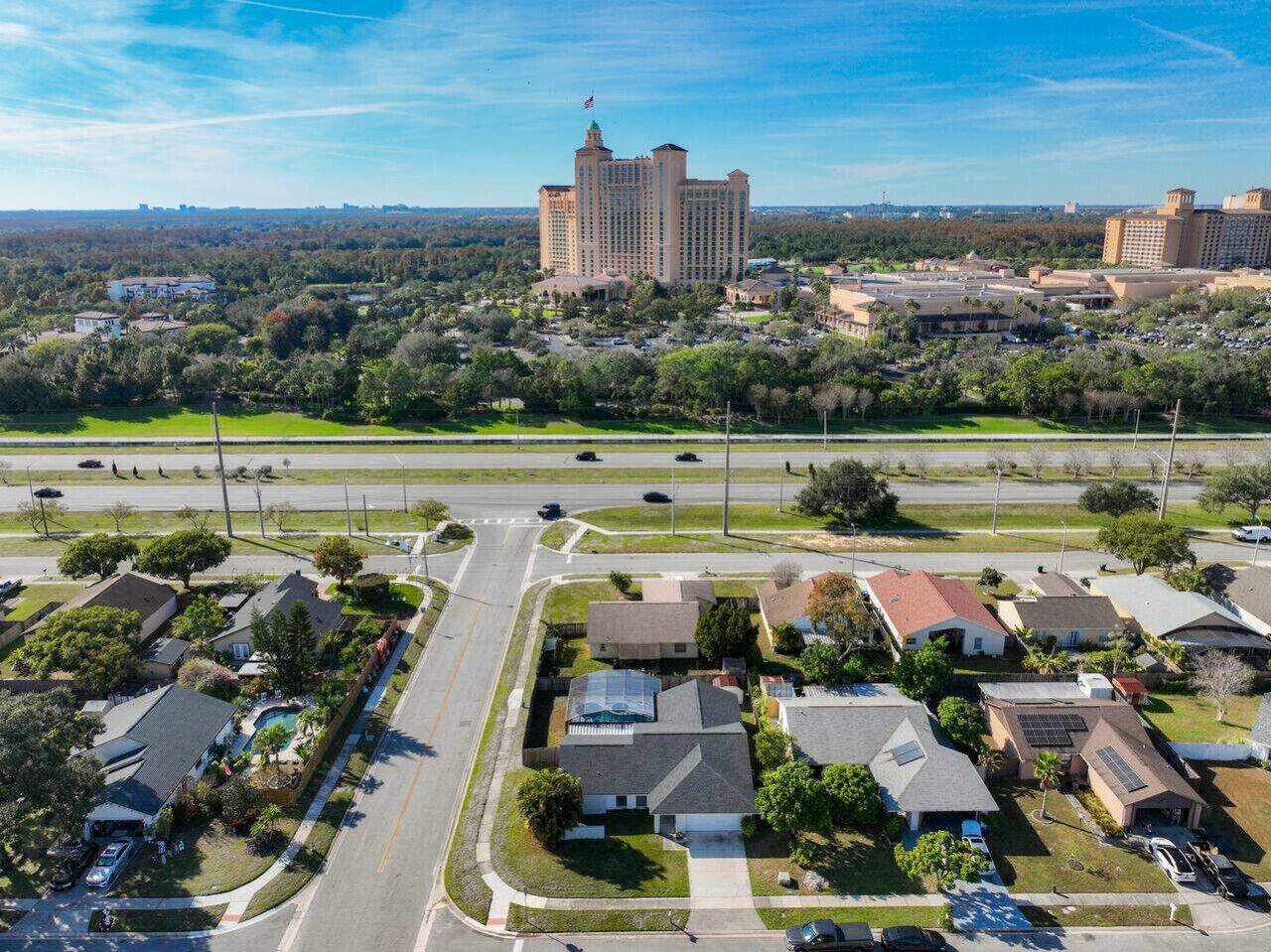 A large hotel with a central tower, surrounded by residential areas and roads.
