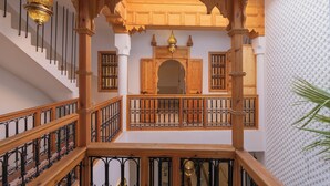 A wooden staircase with ornate railings and a decorative ceiling light. - Riad Jardin d'Orient - Riad with 2 pools in the heart of the Medina (Marrakech)