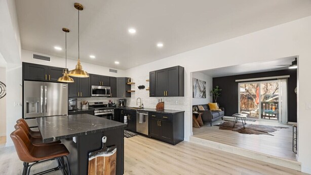 A modern kitchen with dark cabinetry, stainless steel appliances, and a central island. - Downtown Ebony- 1.5 Miles from Whiskey Row (Prescott)