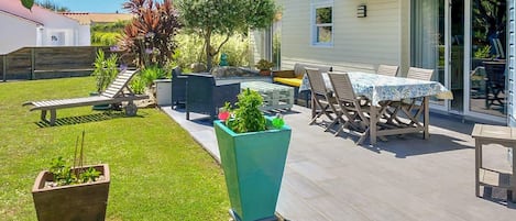 A patio with outdoor furniture, a table, and planters.