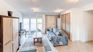 A modern living room with a sofa, a coffee table, and a TV. There is a sliding door leading to a balcony. - 4 bedroom gorgeous home in Saint Raphael (Saint Raphael)