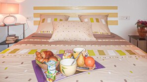 A neatly made bed with a pillow and a blanket, a bedside table with a lamp, and a tray with food and drinks. - 4 bedroom gorgeous home in Saint Raphael (Saint Raphael)