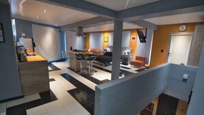 Un vaste espace de vie comprenant une cuisine, un coin repas et un escalier.