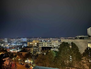 A nighttime cityscape with buildings, a parking area, and trees. - Panoramic apartment with stunning views Tbilisi (Tbilisi)