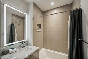 Standaard appartement | Badkamer | Een bad/douchecombinatie, een haardroger, handdoeken, zeep