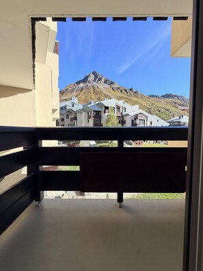 A balcony with a view of a mountain and buildings.
