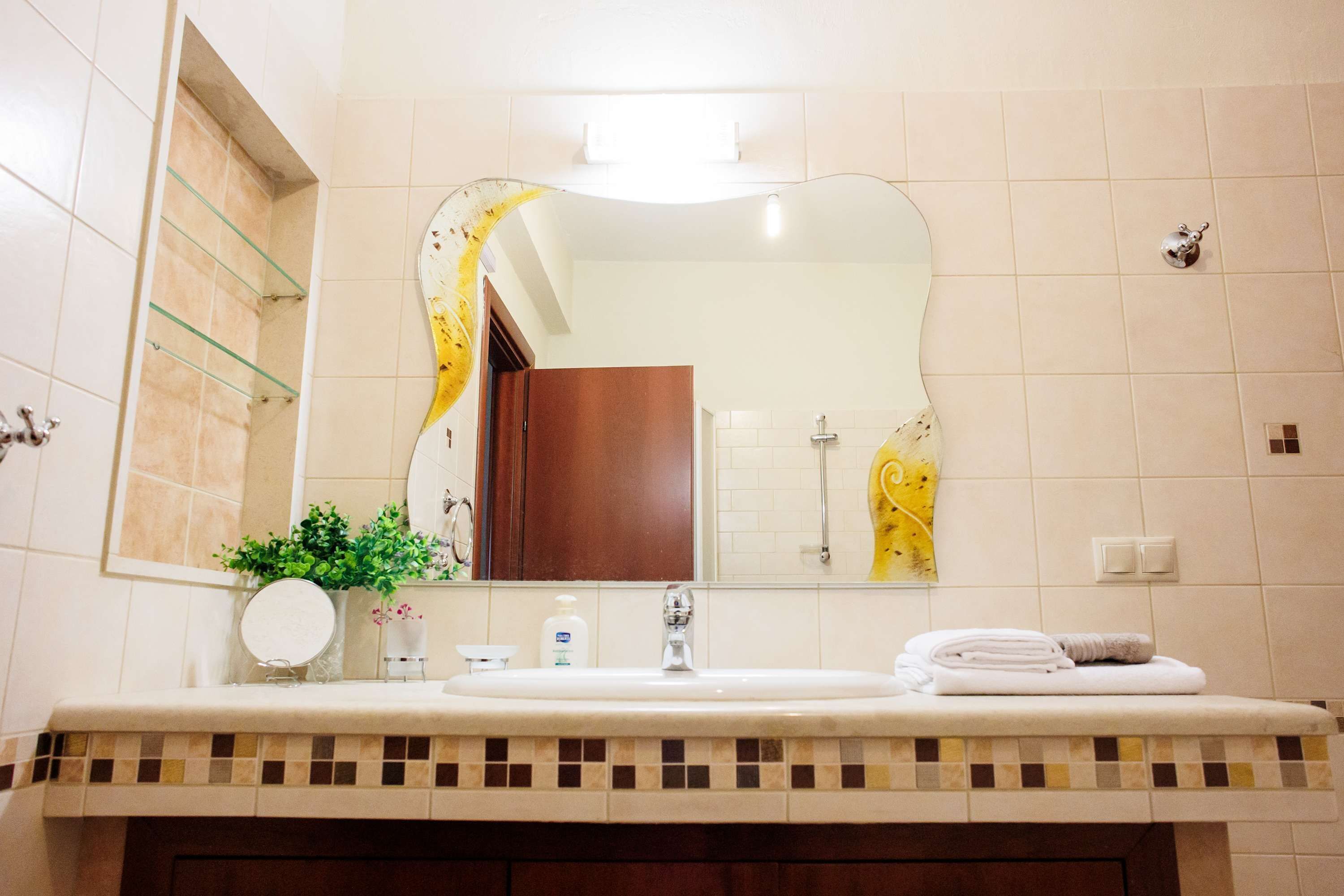 Une salle de bain équipée d’un lavabo, d’un miroir et d’un porte-serviettes.