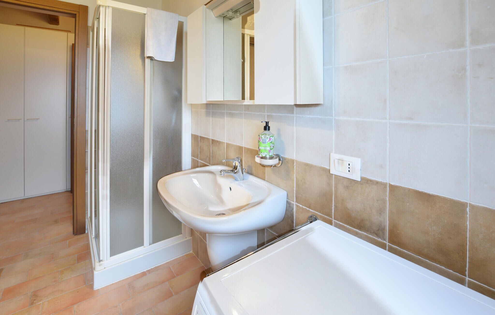 Un baño con ducha, lavamanos y bañera.