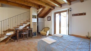 A bedroom with a bed, a desk, a chair, a staircase, and a radiator. - Gorgeous apartment in Loiano with WiFi (Loiano)