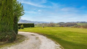 A rural landscape with a gravel path, green fields, and distant hills under a clear sky. - Gorgeous apartment in Loiano with WiFi (Loiano)