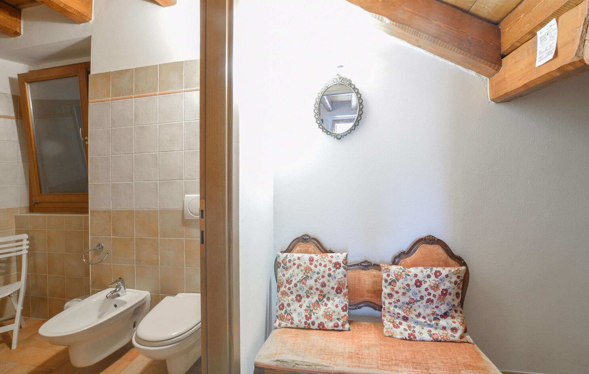 Ein Badezimmer mit einer Bidet-Funktion, Toilette und einem Spiegel.