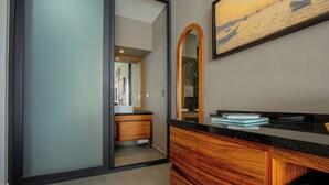 A modern bathroom with a wooden vanity, a large mirror, and a painting on the wall. - LF Hotel Boutique (Playa del Carmen)