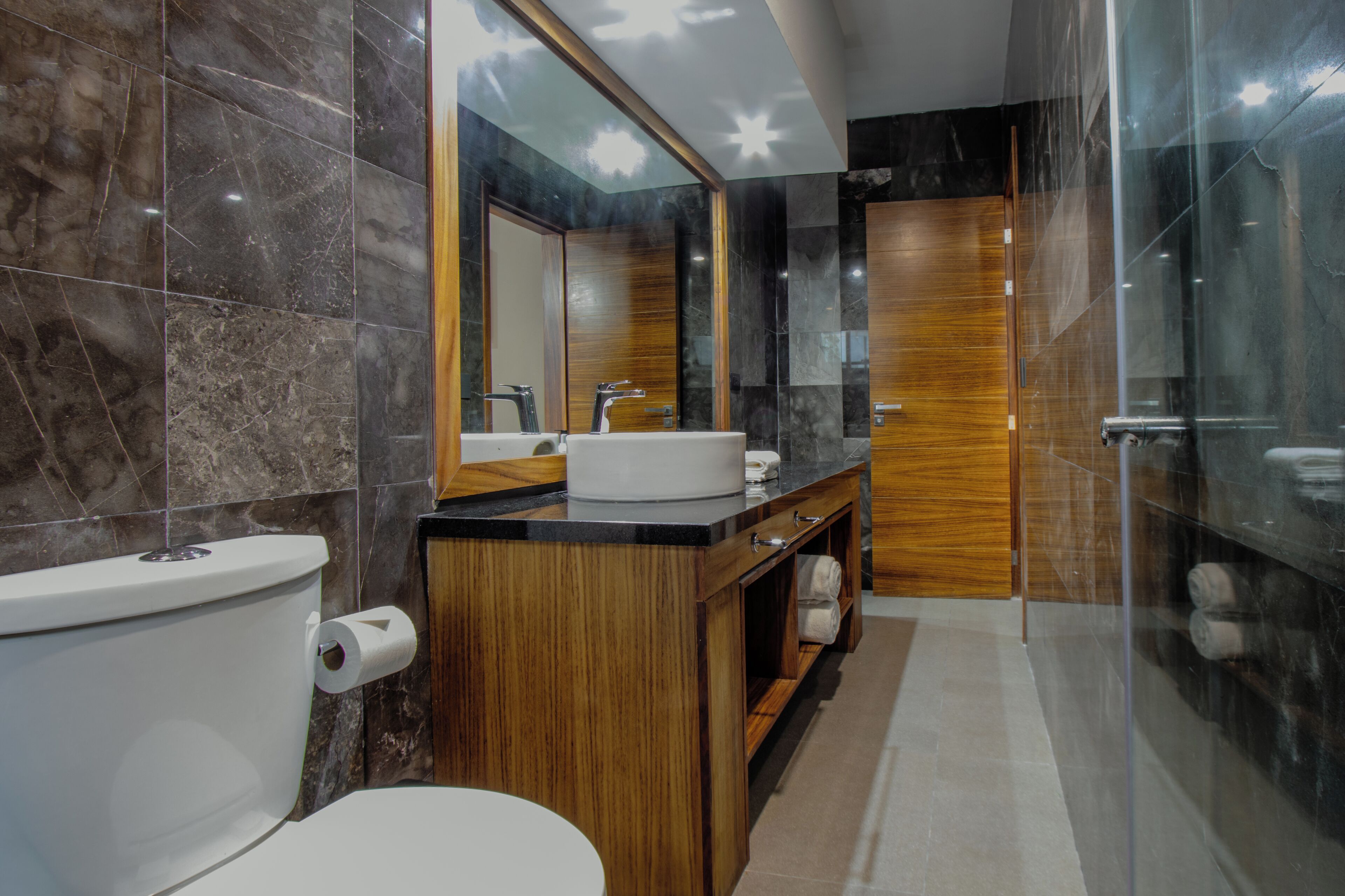 A modern bathroom with a toilet, sink, and shower.