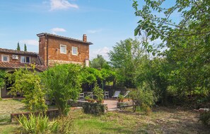 A rustic brick house with a garden patio, outdoor furniture, and a clear sky. - Amazing home in Firenze (Firenze)