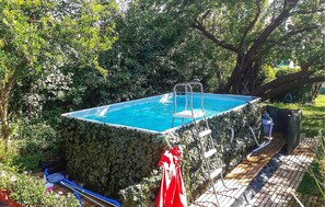 A small, square swimming pool surrounded by dense foliage, with a ladder leading into the water. - Amazing home in Firenze (Firenze)