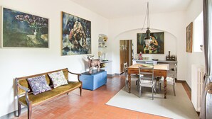 A dining area with a wooden table and chairs, a blue cabinet, and a hanging light fixture. - Amazing home in Firenze (Firenze)