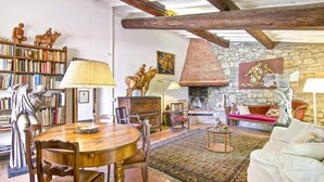 A cozy living room with a fireplace, bookshelves, and rustic decor. - Amazing home in Firenze (Firenze)