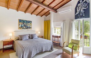 A bedroom with a bed, a nightstand, a painting, a window with curtains, and a chair. - Amazing home in Firenze (Firenze)