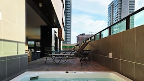 A rooftop pool area with a hot tub, lounge chairs, and a view of surrounding high-rise buildings. - Apê Design Vista Mar, Piscina, Hidro e Academia (Maceió)
