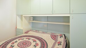 Un dormitorio con cama, mesita de noche y armario.