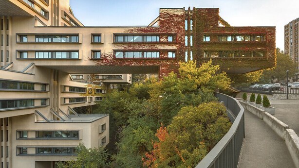 Un bâtiment moderne doté d’une architecture originale, avec une partie en porte-à-faux et un jardin luxuriant.