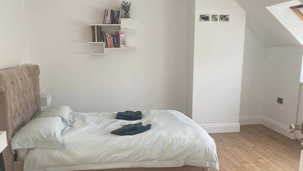 A bedroom with a bed, wooden flooring, a bookshelf, and a small plant. - A large 4 bed family home to make great memories in the West Coast of Ireland. (Westport)