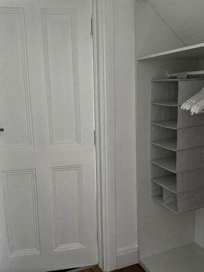 A white closet with a hanging rod and shelves. - A large 4 bed family home to make great memories in the West Coast of Ireland. (Westport)