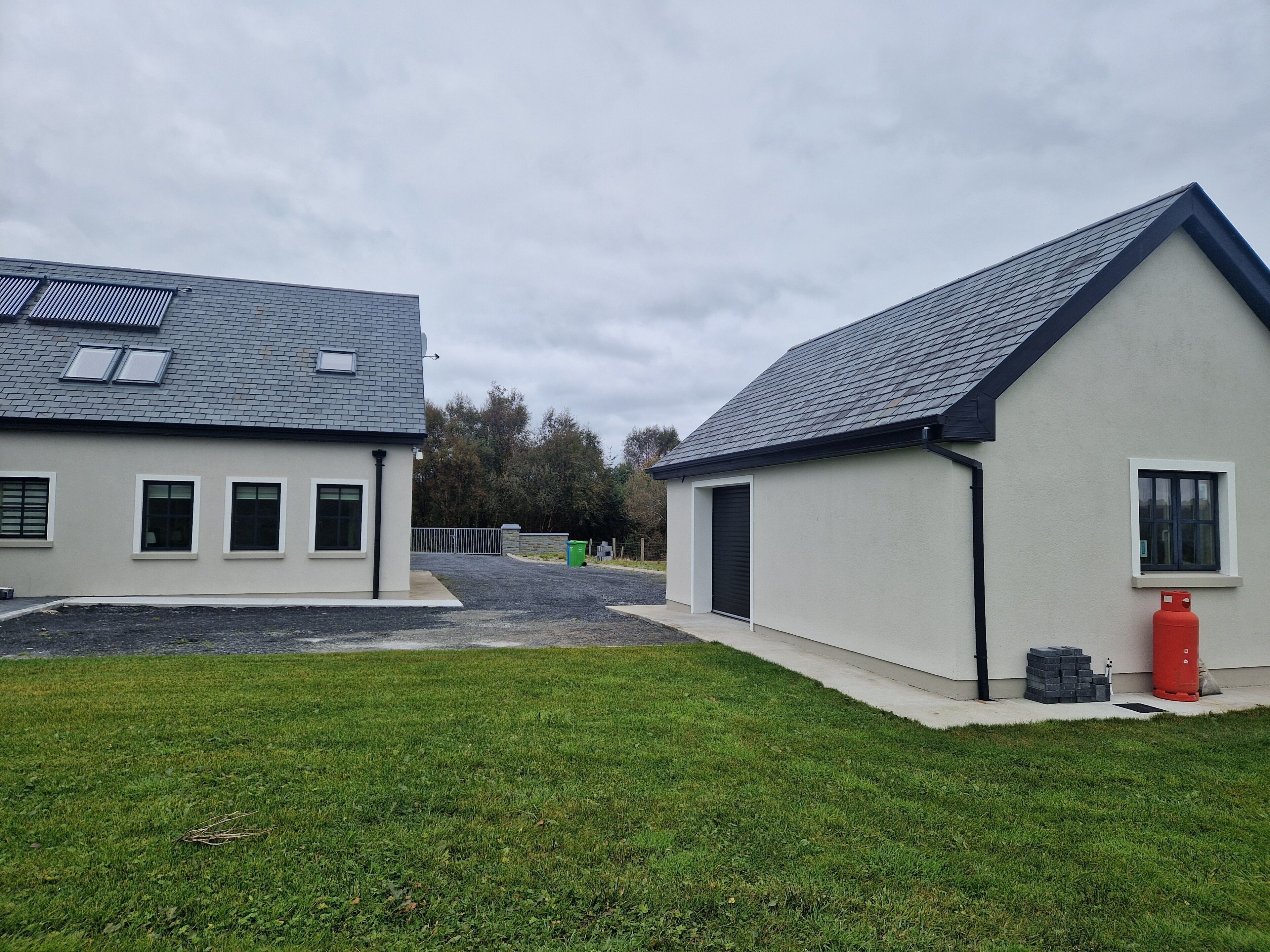 Un bâtiment doté d’un toit plat, d’un garage et d’une petite fenêtre.