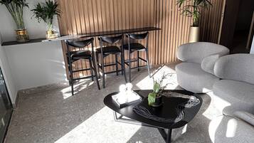 Una sala de estar moderna con sofá, una mesa de centro y una zona de comedor con sillas.
