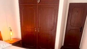 A hotel room with a large bed, a wardrobe, and a door. - Caparica Escape By Gt House (Almada)