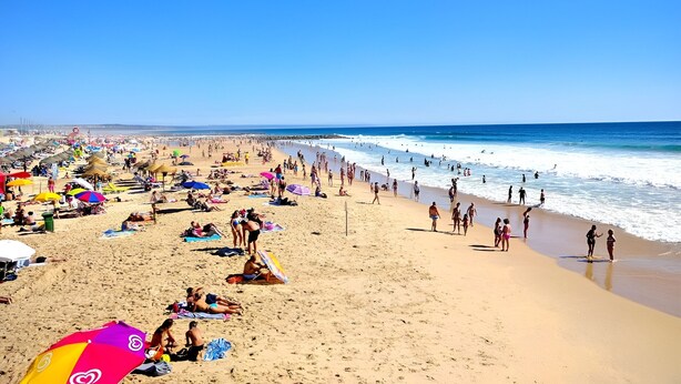 A crowded beach with umbrellas and people sunbathing. - Caparica Escape By Gt House (Almada)