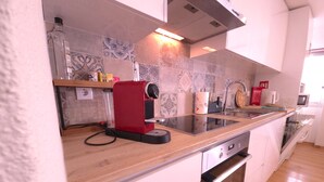 A modern kitchen with a built-in stove, a coffee machine, and a microwave. - Caparica Escape By Gt House (Almada)