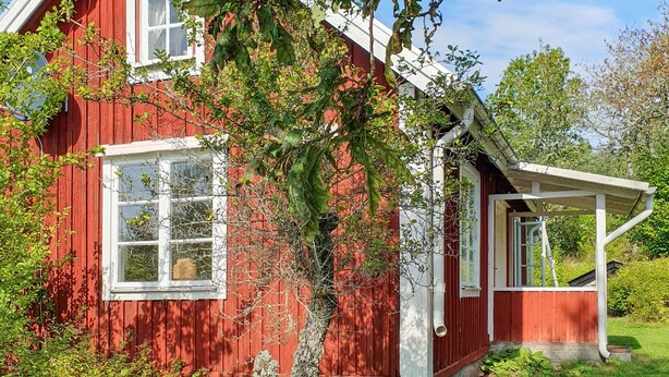 A red wooden house with white trim, a window, and a small porch. - 2 bedroom amazing home in Fagerhult (Fagerhult)