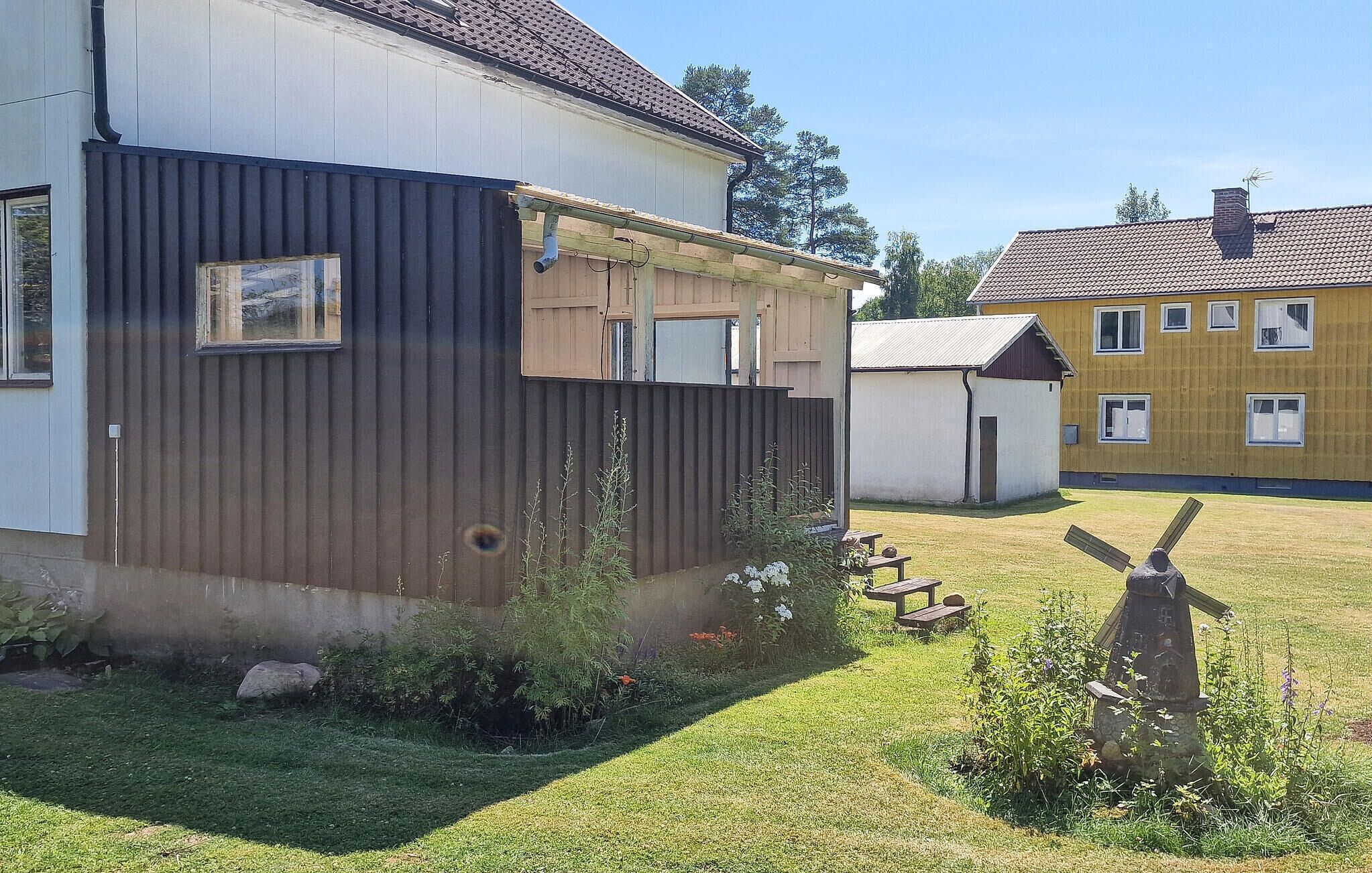 A residential area with houses, a windmill, and a grassy yard.