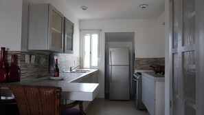 A modern kitchen with a built-in refrigerator, a sink, and a dining area with a chair. - Nice apartment located in the safest area of Acapulco. 4km from Costera (Acapulco de Juárez)