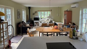 Ein gemütliches Wohnzimmer mit Kamin, einem Essbereich mit Tisch und Stühlen sowie einem Sofa.