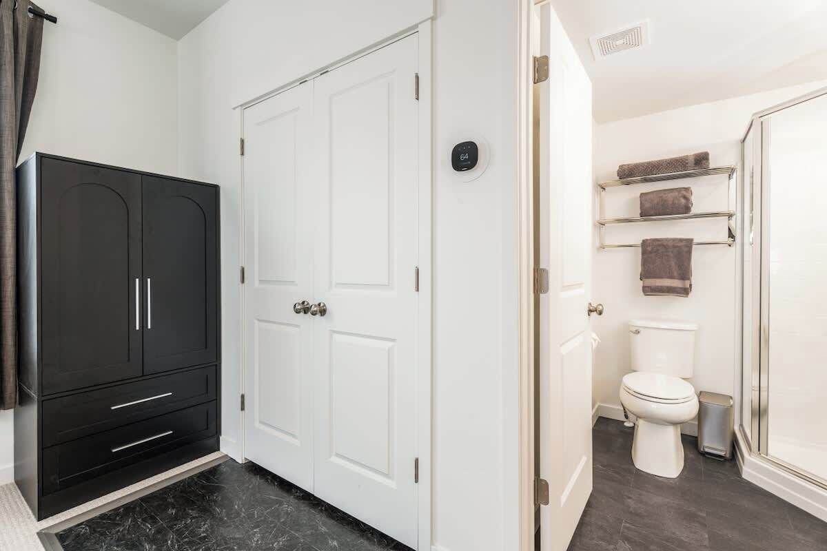 A bathroom with a toilet, a shower, and a towel rack.